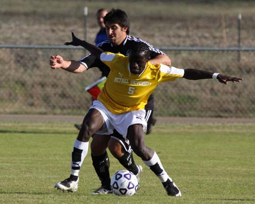 Bethel's Joseph Omondi battles Kansas Wesleyan University's Anthony Russo for position. Bethel won the match 3-1.
